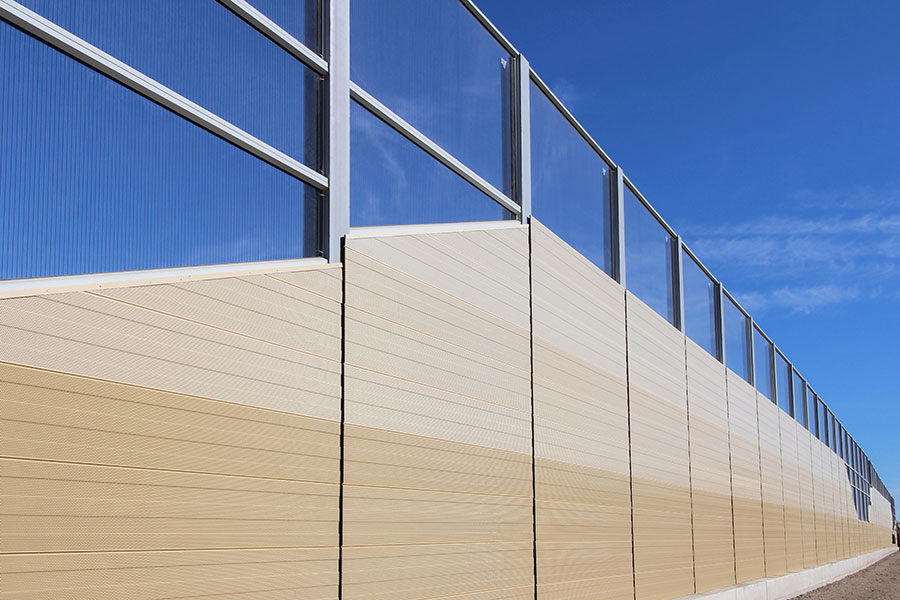 Lärmschutzwand entlang der Ortsstraße mit transparenten Elementen im oberen Bereich und hochabsorbierenden Lärmschutzelementen im unteren Bereich