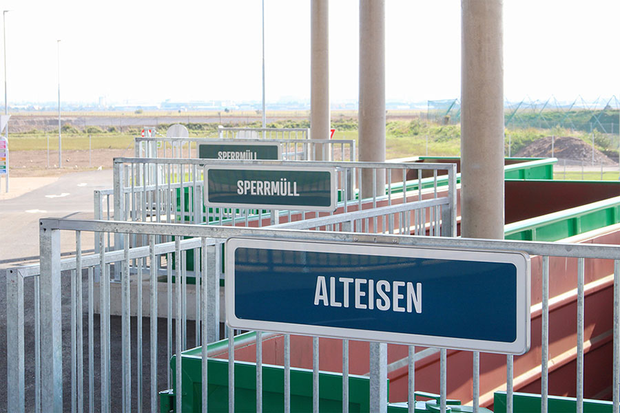 Beschilderung der Wertstoffsammelbehälter, im Vordergrund "Alteisen"