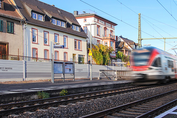 Lärmschutzwand an einer Bahnstrecke an die die Häuser nah herangebaut sind.